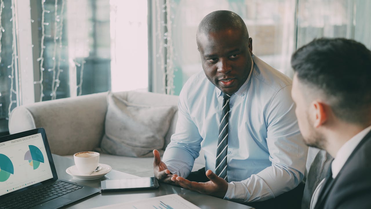 Two businessmen discussing strategies over coffee in a modern cafe.